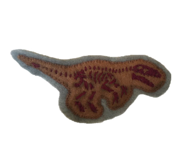 A crimson embroidered dinosaur skeleton on a patch of brown and grey felt.